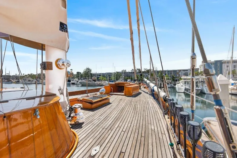 Slide: The Image of 1961 Vic Franck Custom yacht deck with wooden finish, docked in a marina under clear blue skies. - 25