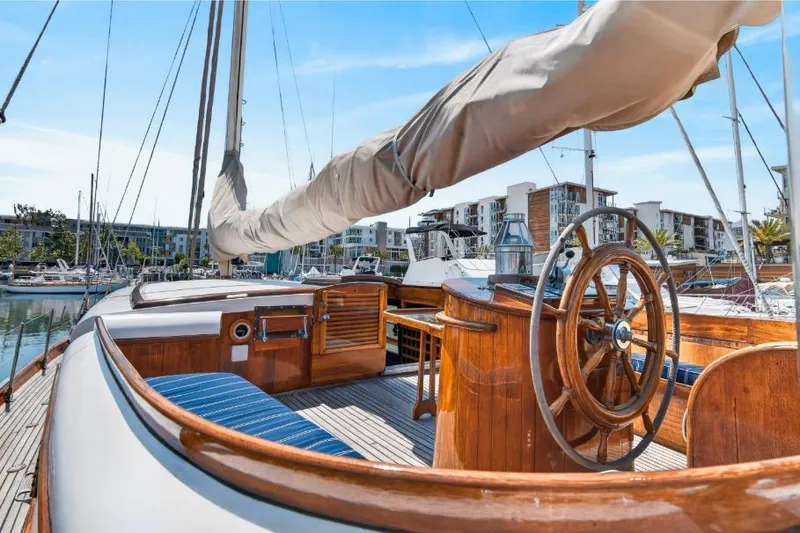 Slide: The Image of 1961 Vic Franck Custom yacht with wooden helm, docked in marina under clear sky. - 28