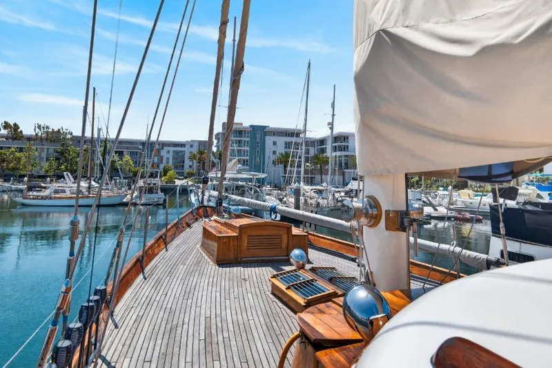 Slide: The Image of Deck view of a 1961 Vic Franck Custom yacht docked in a marina. - 29