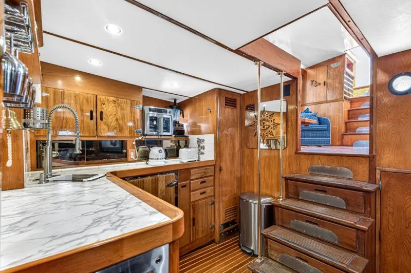 Slide: The Image of 1961 Vic Franck Custom yacht interior with wooden cabinetry, marble countertops, and staircase. - 3