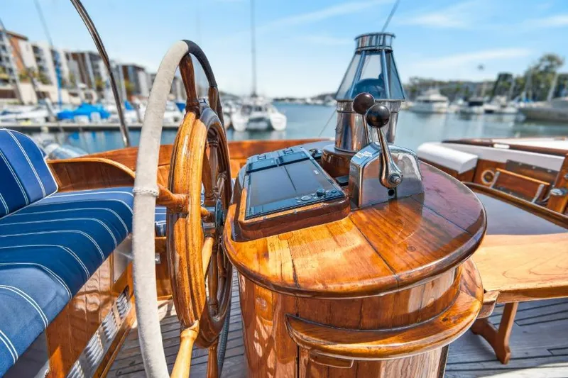 Slide: The Image of Wooden helm of a 1961 Vic Franck Custom yacht, featuring polished controls and blue seating. - 30