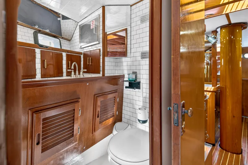 Slide: The Image of Luxurious 1961 Vic Franck Custom yacht bathroom with wood cabinetry and white tile accents. - 6