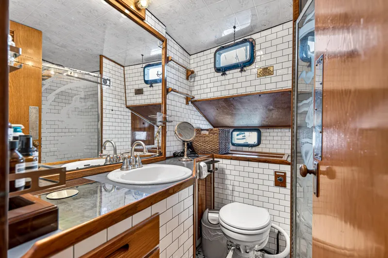 Slide: The Image of Vintage 1961 Vic Franck Custom yacht bathroom with white tiles and wooden accents. - 8