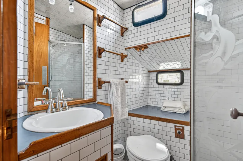 Slide: The Image of 1961 Vic Franck Custom yacht bathroom with white tiles, wooden accents, and modern fixtures. - 9