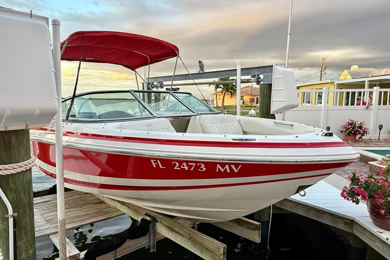 The Image of 2004 Regal 2000 Bowrider boat with red accents docked at a marina. - 0