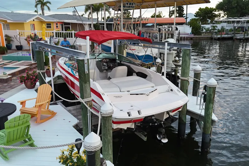 Slide: The Image of 2004 Regal 2000 Bowrider docked at a waterfront with colorful chairs. - 10
