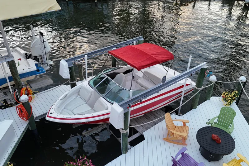 Slide: The Image of 2004 Regal 2000 Bowrider docked with red canopy, surrounded by colorful chairs. - 12