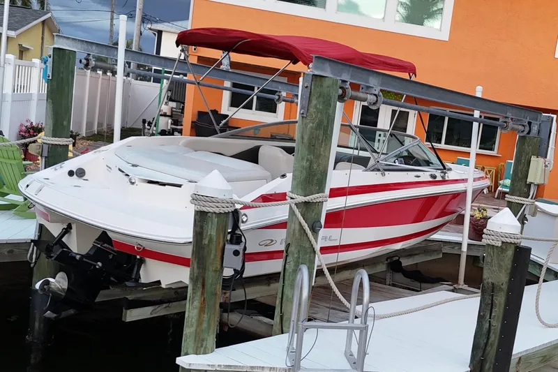 Slide: The Image of 2004 Regal 2000 Bowrider boat docked with red canopy and white-red design. - 13