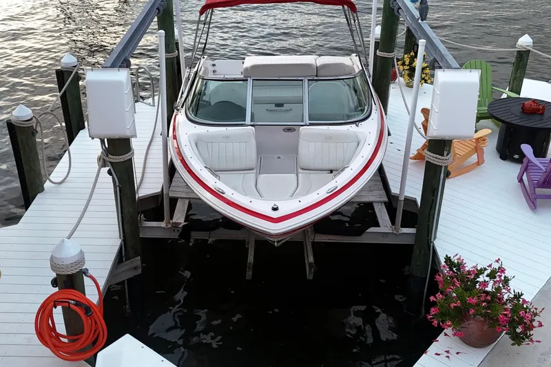 Slide: The Image of 2004 Regal 2000 Bowrider docked at a scenic waterfront with colorful chairs and flowers. - 14