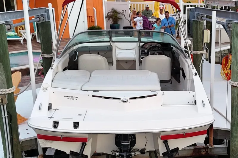 Slide: The Image of 2004 Regal 2000 Bowrider boat docked with people in the background. - 16