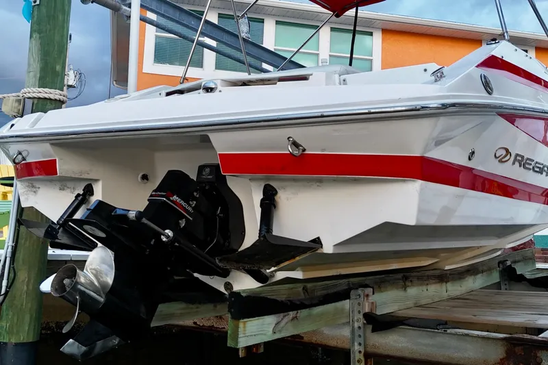 Slide: The Image of 2004 Regal 2000 Bowrider boat on dock, featuring red accents and outboard motor. - 17