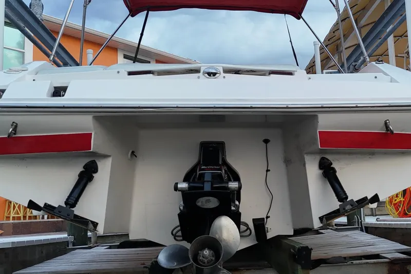 Slide: The Image of 2004 Regal 2000 Bowrider boat stern view with outboard motor and red accents. - 18