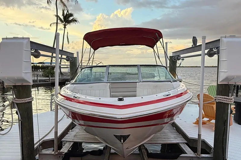 Slide: The Image of 2004 Regal 2000 Bowrider boat docked at sunset with red canopy. - 2