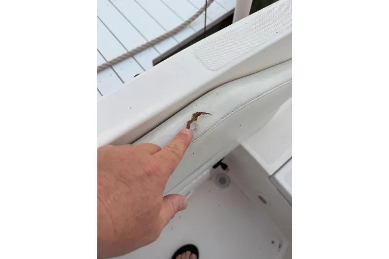 Slide: The Image of Hand pointing at tear in white seat of 2004 Regal 2000 Bowrider boat. - 31