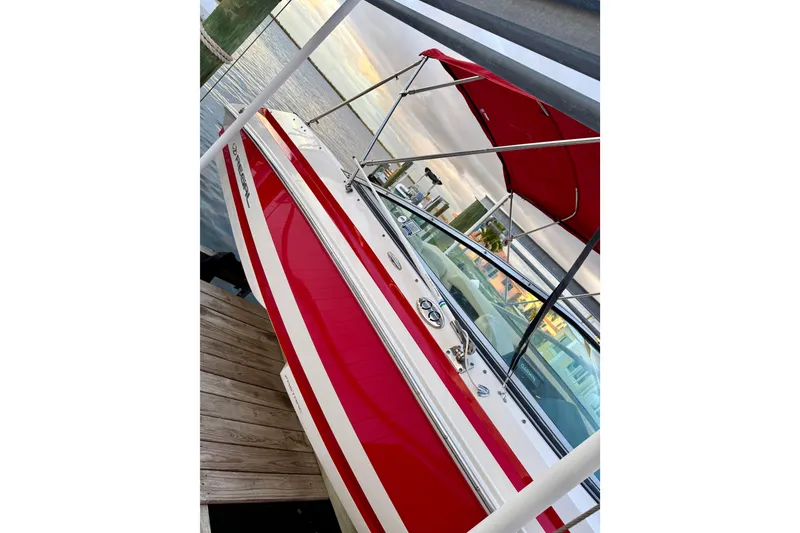 Slide: The Image of Red and white 2004 Regal 2000 Bowrider boat docked with canopy. - 4