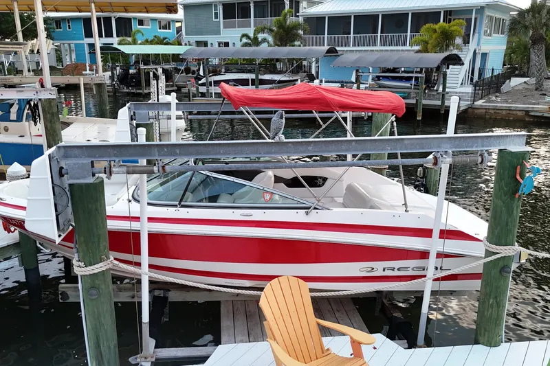 Slide: The Image of 2004 Regal 2000 Bowrider boat with red canopy docked at a marina. - 9