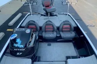 Slide: The Image of 2010 Nitro Z-7 boat interior with seating and motor, parked on pavement. - 9
