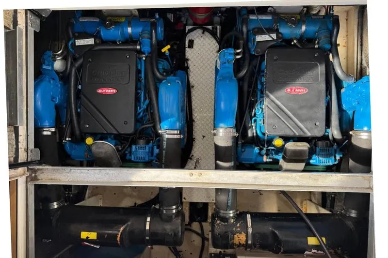 Slide: The Image of Engine compartment of a 2002 Cruisers Yachts 3575 Express, featuring twin blue marine engines. - 11