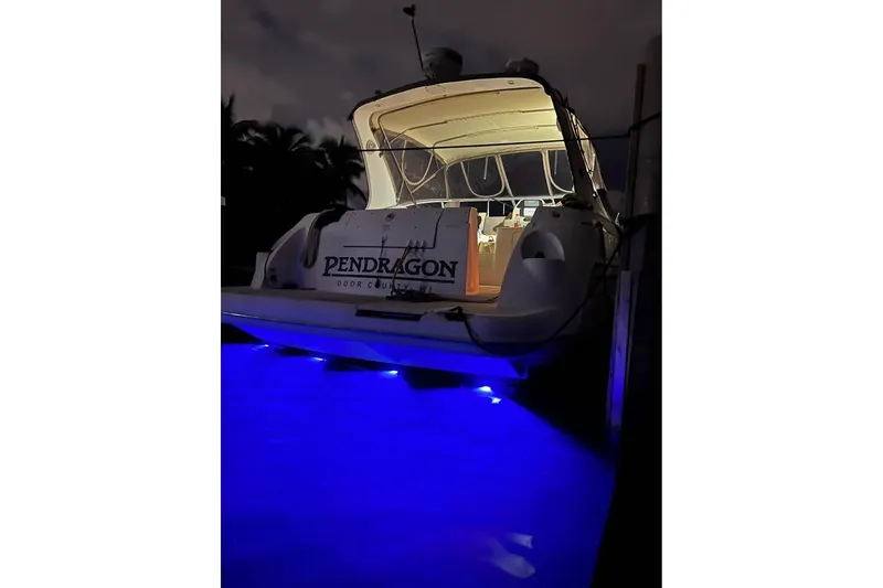 Slide: The Image of 2002 Cruisers Yachts 3575 Express with blue underwater lights at night. - 15