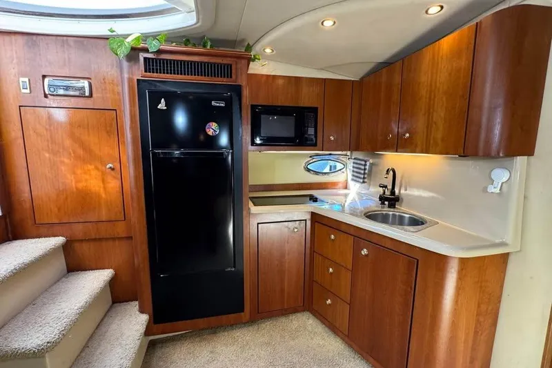 Slide: The Image of 2002 Cruisers Yachts 3575 Express interior kitchen with wood cabinets and modern appliances. - 16