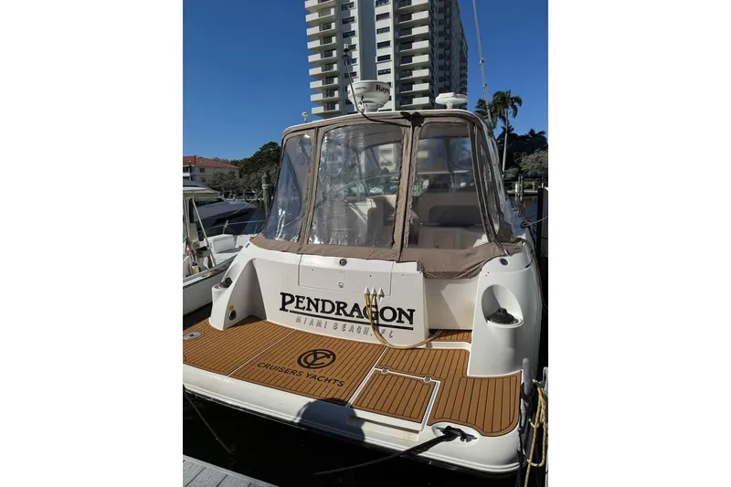 Slide: The Image of 2002 Cruisers Yachts 3575 Express docked, featuring a spacious deck and clear enclosure. - 3