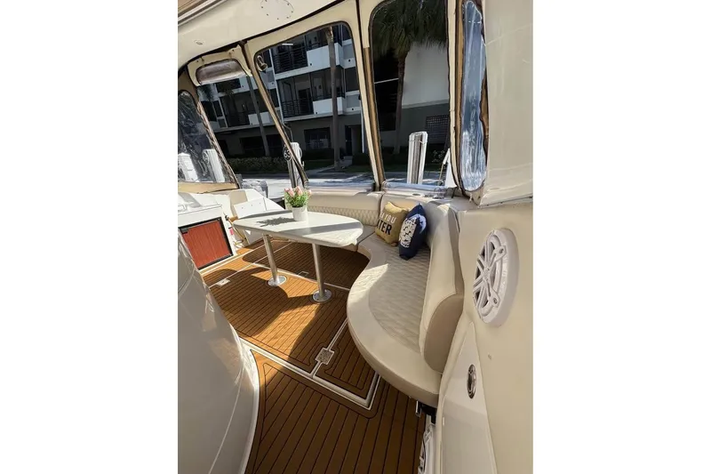 Slide: The Image of 2002 Cruisers Yachts 3575 Express interior with seating, table, and decorative pillows. - 9