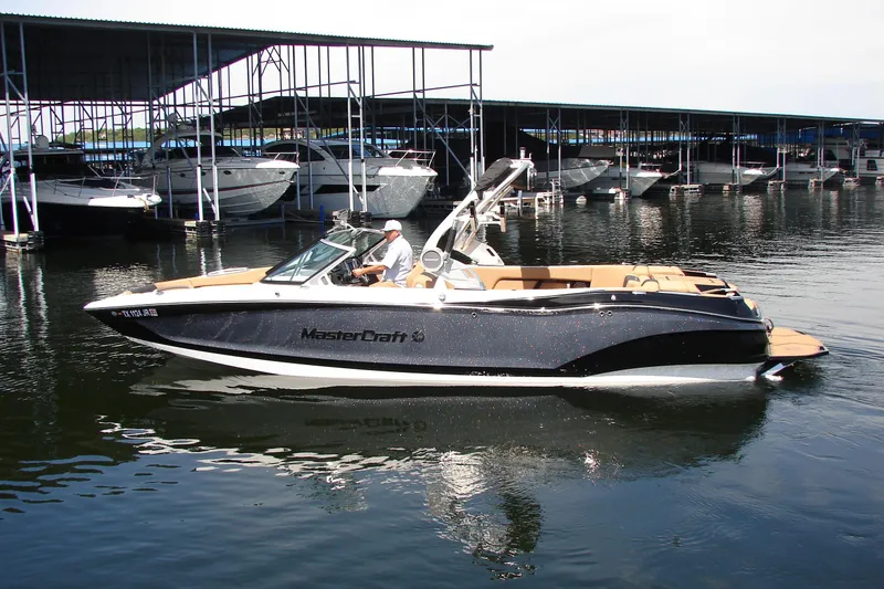 The Image of 2021 MasterCraft X26 boat docked at marina, sleek design, calm water. - 0