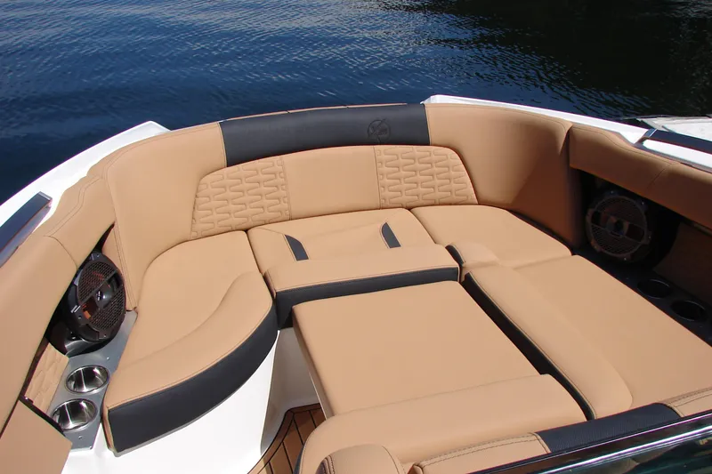 Slide: The Image of Luxurious seating area on a 2021 MasterCraft X26 boat, featuring tan upholstery and cup holders. - 12