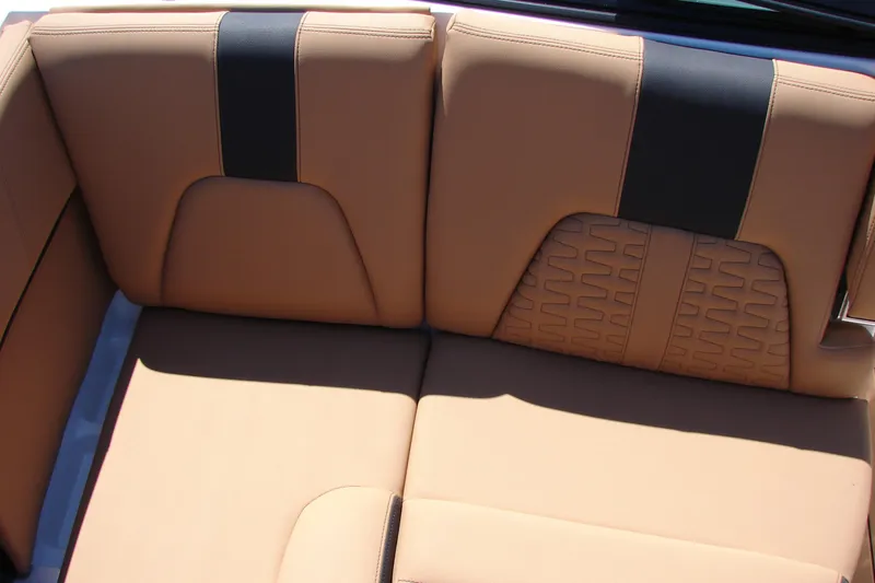 Slide: The Image of 2021 MasterCraft X26 boat interior with tan and black cushioned seating. - 13