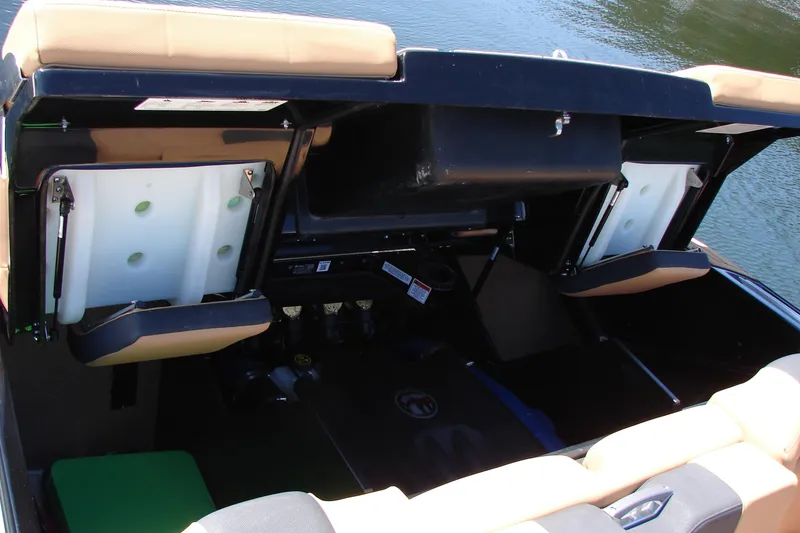 Slide: The Image of 2021 MasterCraft X26 boat interior storage compartments open by the water. - 22