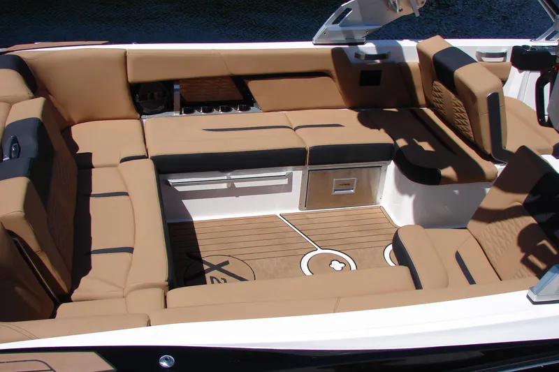 Slide: The Image of 2021 MasterCraft X26 boat interior with tan and black seating, showcasing luxury and comfort. - 23