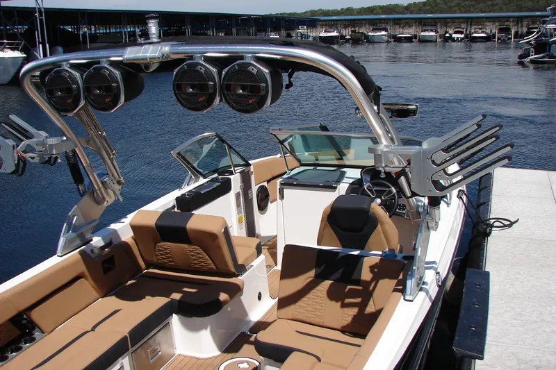 Slide: The Image of 2021 MasterCraft X26 boat with luxurious seating and advanced audio system at a marina. - 24