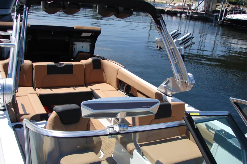 Slide: The Image of 2021 MasterCraft X26 boat interior with luxurious seating and sleek design on a calm lake. - 26
