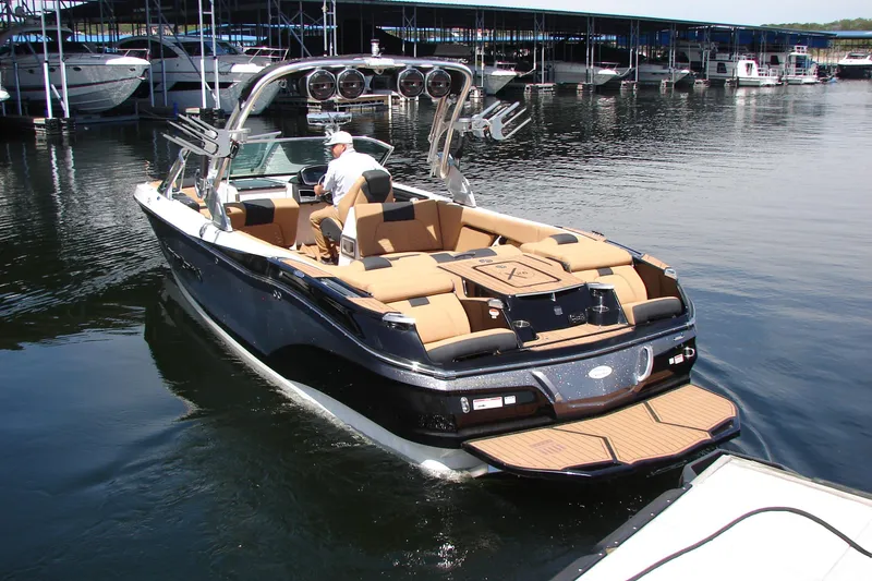 Slide: The Image of 2021 MasterCraft X26 boat with tan seating, docked in a marina. - 3
