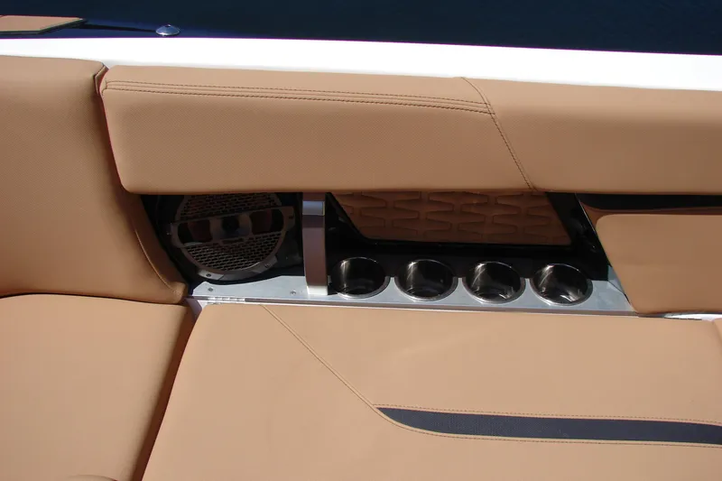 Slide: The Image of 2021 MasterCraft X26 boat interior with tan seating and built-in cup holders. - 35