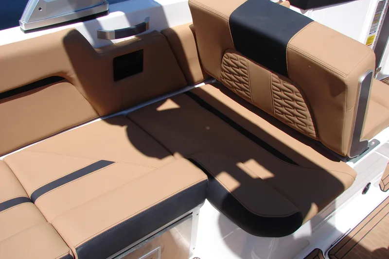 Slide: The Image of 2021 MasterCraft X26 boat interior with tan and black cushioned seating. - 36