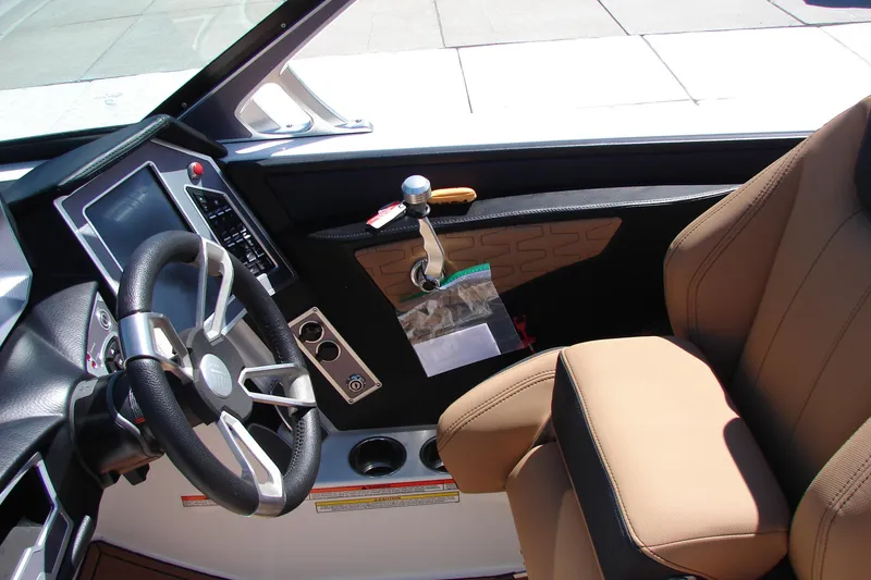Slide: The Image of Interior of a 2021 MasterCraft X26 boat, featuring a sleek steering wheel and modern controls. - 38
