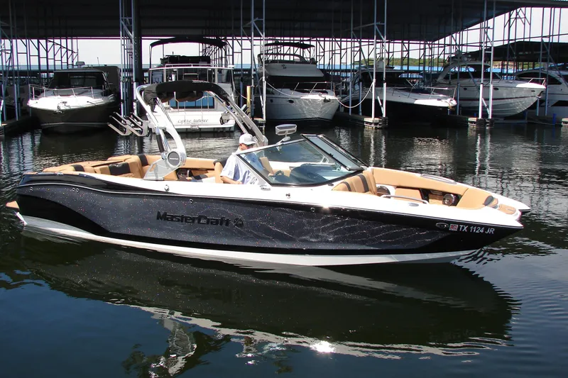 Slide: The Image of 2021 MasterCraft X26 boat docked in marina, featuring sleek design and luxurious seating. - 4