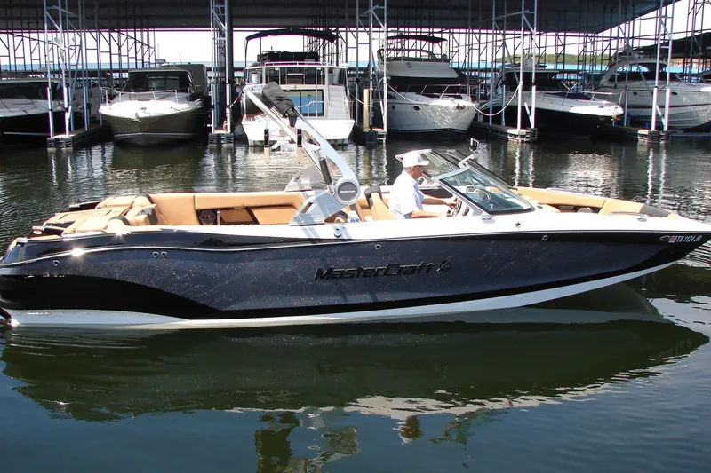 Slide: The Image of 2021 MasterCraft X26 boat docked in marina, featuring sleek design and luxurious seating. - 5