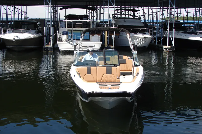 Slide: The Image of 2021 MasterCraft X26 boat docked in marina, surrounded by other vessels. - 8