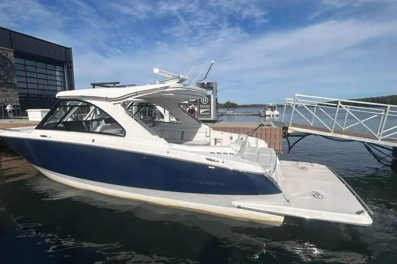 Slide: The Image of 2025 Regal LS36 luxury boat docked at marina under clear blue sky. - 11