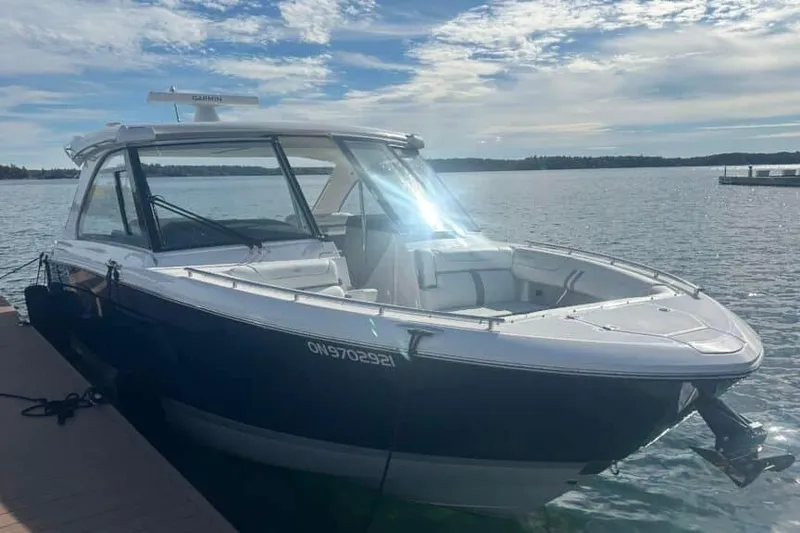 Slide: The Image of 2025 Regal LS36 boat docked on a sunny day with calm waters. - 13