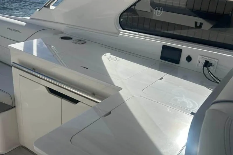 Slide: The Image of Interior view of 2025 Regal LS36 boat with sleek white countertop and built-in outlets. - 19