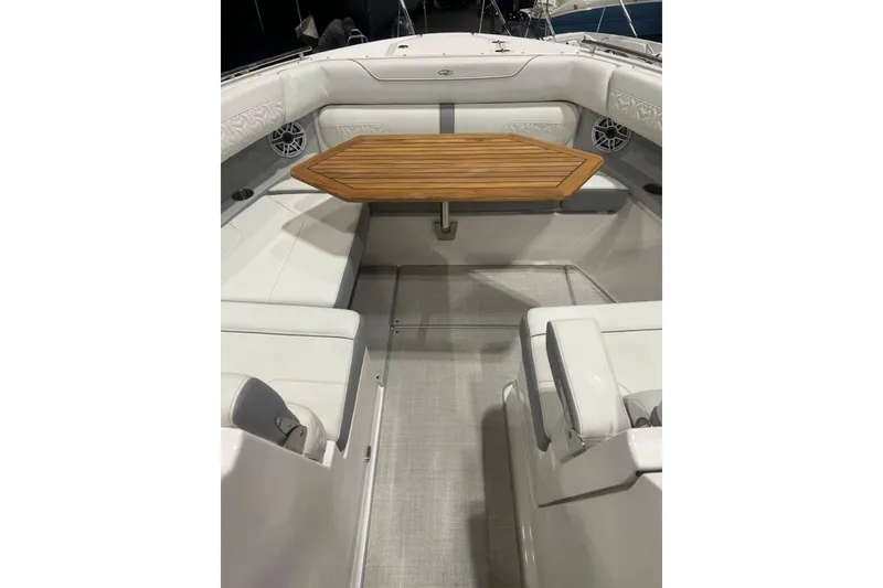 Slide: The Image of 2025 Regal LS36 boat interior with white seating and wooden table. - 6
