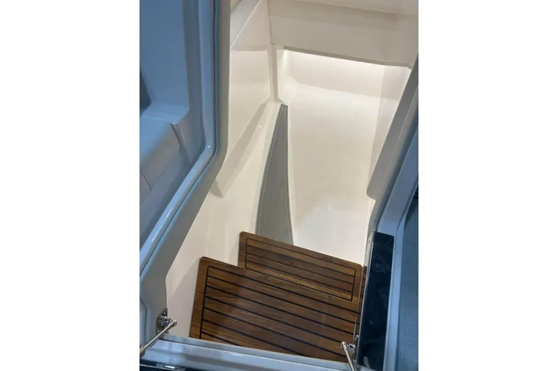 Slide: The Image of Staircase inside 2025 Regal LS36 boat, featuring sleek wooden steps and modern design. - 7