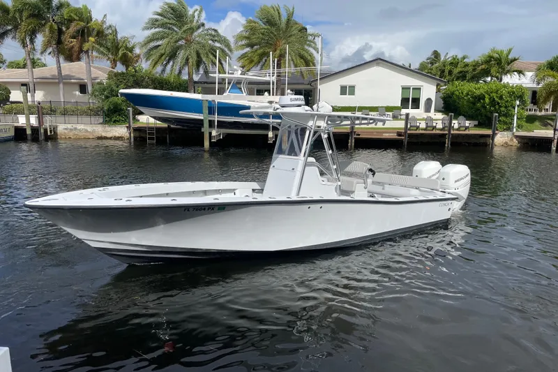 The Image of 2015 Conch 27 boat on water, dockside with palm trees and houses in background. - 0