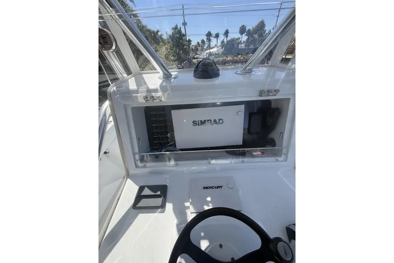 Slide: The Image of 2015 Conch 27 boat deck with sleek design, docked near palm trees. - 11