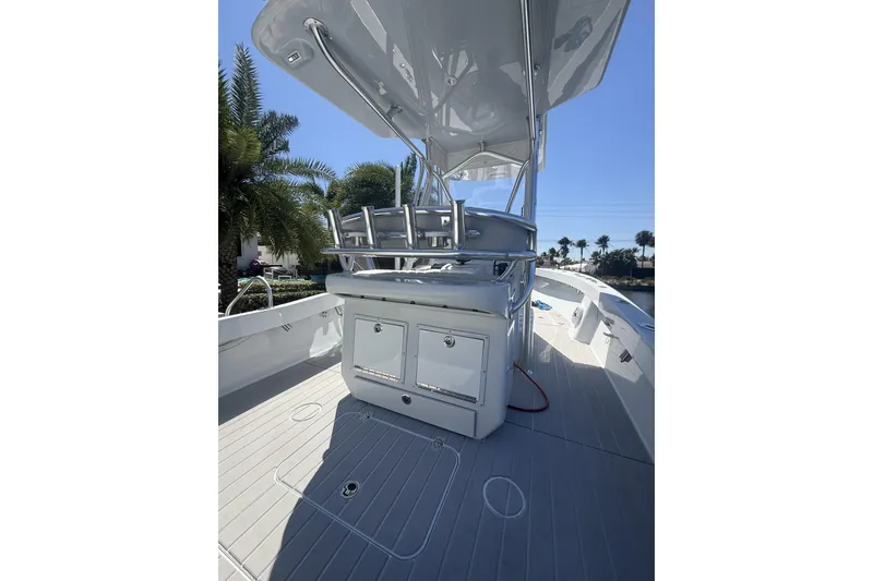 Slide: The Image of 2015 Conch 27 boat with T-top, docked near waterfront homes and palm trees. - 13