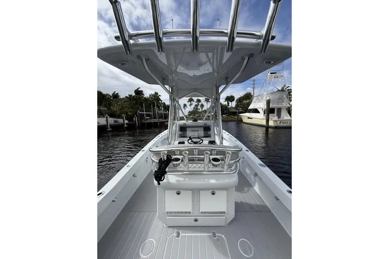 Slide: The Image of 2015 Conch 27 boat with sleek design, docked near palm trees and waterway. - 19