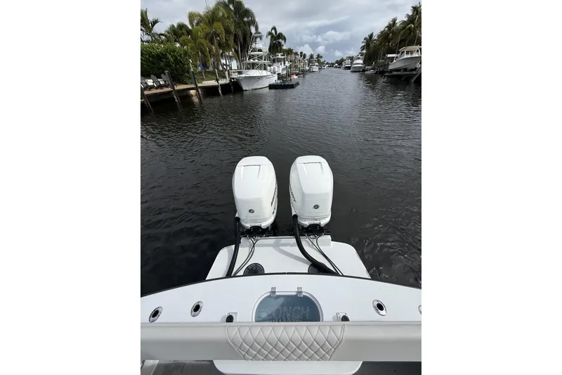 Slide: The Image of 2015 Conch 27 boat with dual outboard motors on a scenic waterway. - 22